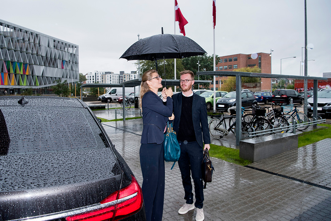 Uddannelses- og forskningsminister Ane Halsboe-Jørgensen står med paraply ude foran IBA.